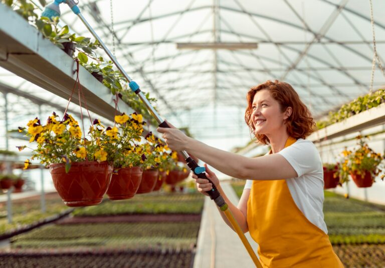 Cheerful gardener watering plants