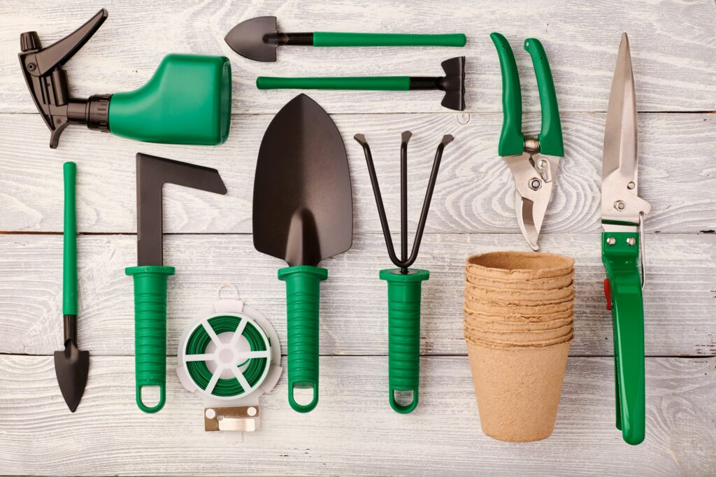 Gardening tools on wooden background flat lay